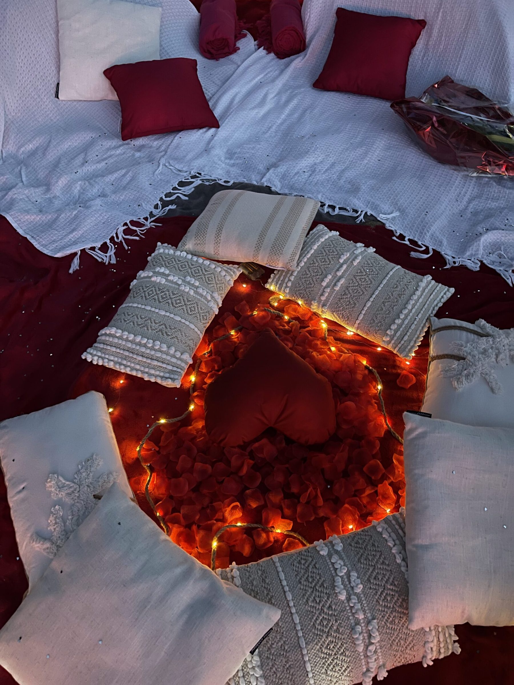 Coussin cœur au centre d'un tapis de pétales et de guirlandes