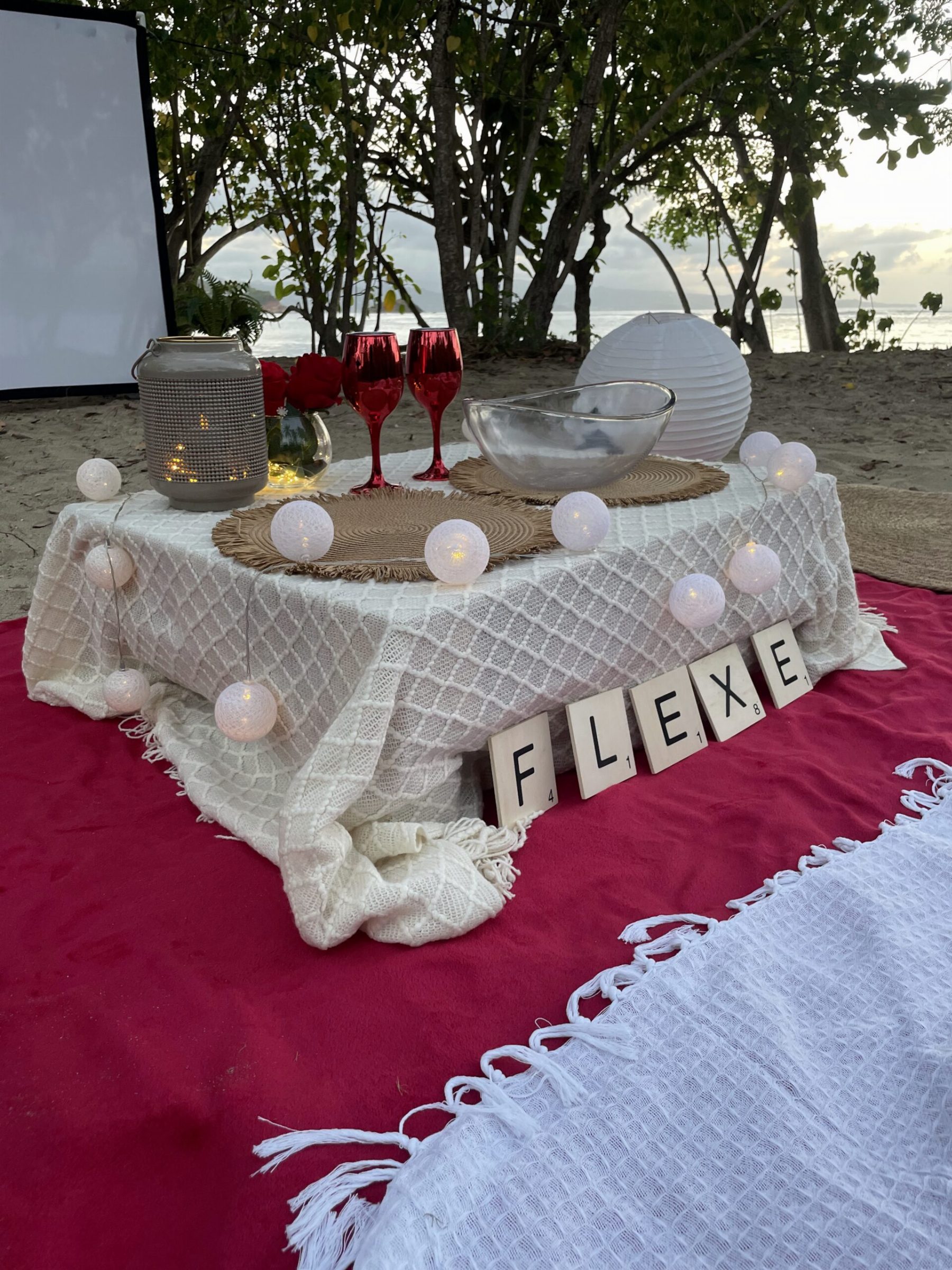 Table dressée face à la mer, guirlande lumineuse et lettres FLEXE