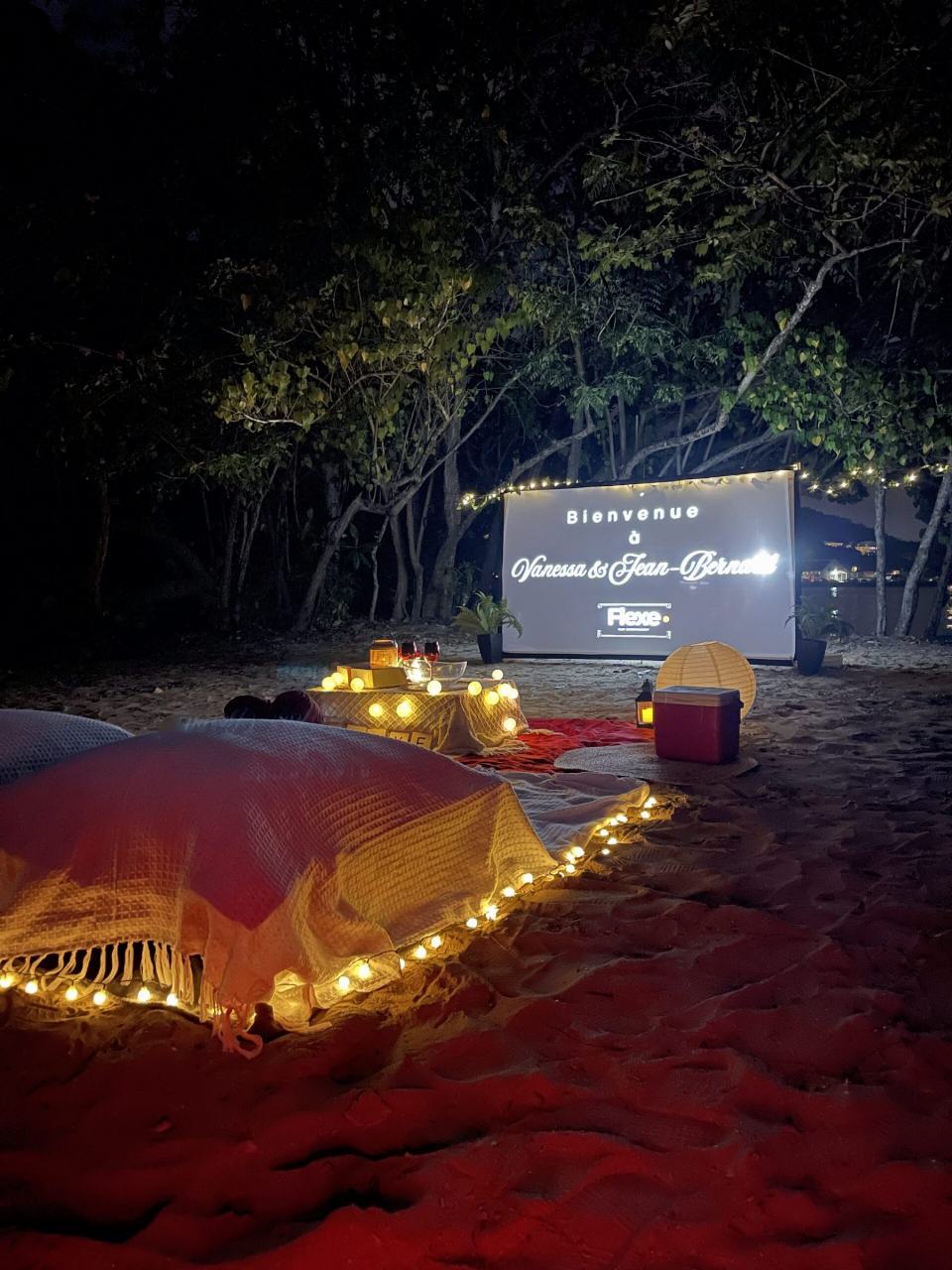 Plage de nuit : couchage cerné de guirlandes face à l'écran allumé